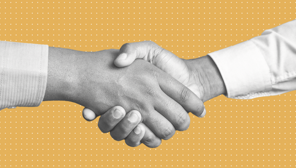 Two recruiters shaking hands as part of the recruitment process.